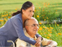 Woman hugging man in wheelchair in a field