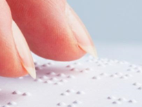 Fingers scanning a braille page